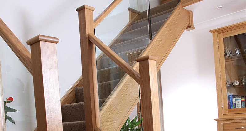 looking up at embedded glass staircase with oak posts, rails and stringers