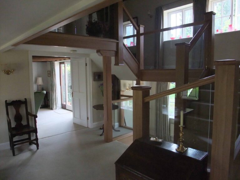 Oversized newels in an oak and glass staircase renovation