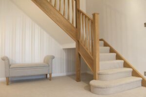 Cool cream carpet on a new oak staircase with feature step and stylish targeted oak spindles
